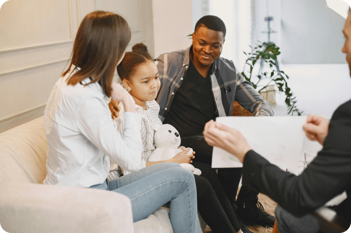 Family with a child sitting together during a therapy session with a counselor