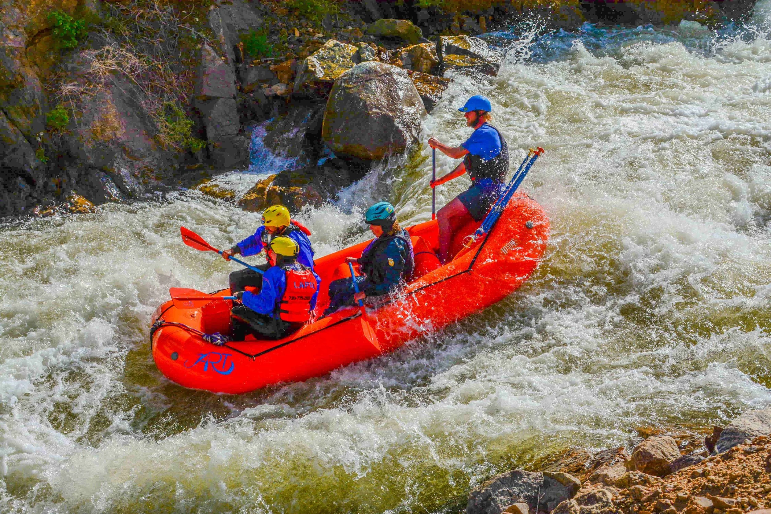 Group whitewater rafting through Class III rapids on Clear Creek in Idaho Springs, Colorado