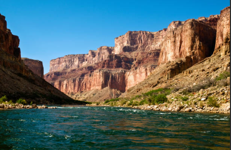 Colorado River flowing through Grand Canyon with cliffs in the background
