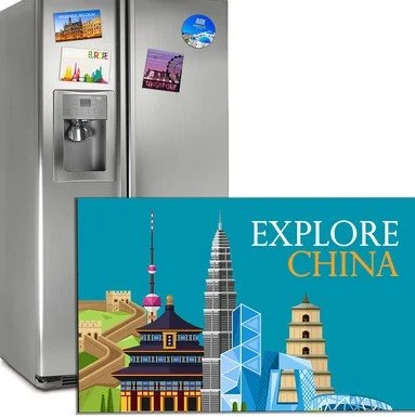 A refrigerator with three magnets and a water dispenser, beside a book titled 'Explore China' featuring famous Chinese landmarks.
