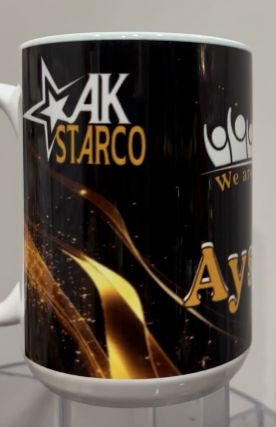 A black coffee mug with gold and white design featuring the name 'AK Starco' and some abstract graphics.
