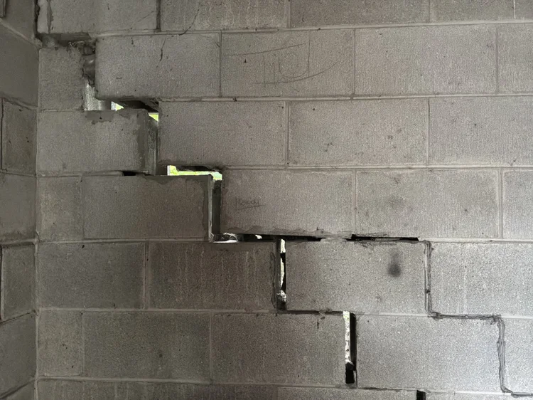 Stepped diagonal crack through a block foundation wall