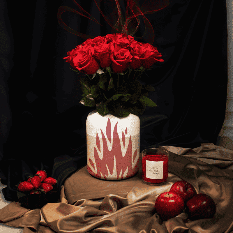 Red roses in vase with flame on it.