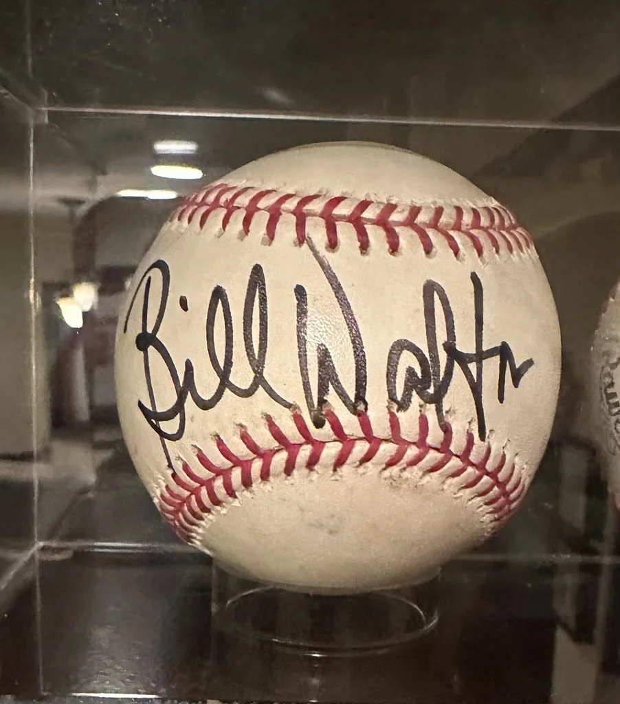 Autographed baseball signed by Bill Womack displayed in a glass case.