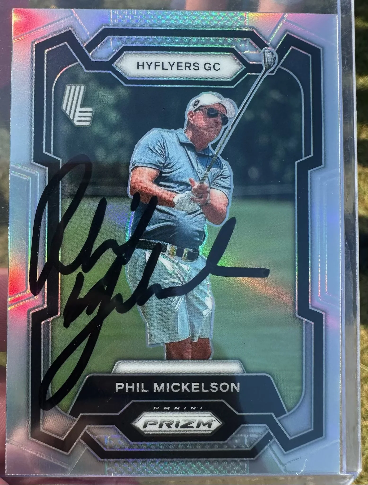 A holographic sports trading card featuring golfer Phil Mickelson, with a signature in black marker and the text 'HYFLYERS GC' at the top and 'PHIL MICKELSON' at the bottom.