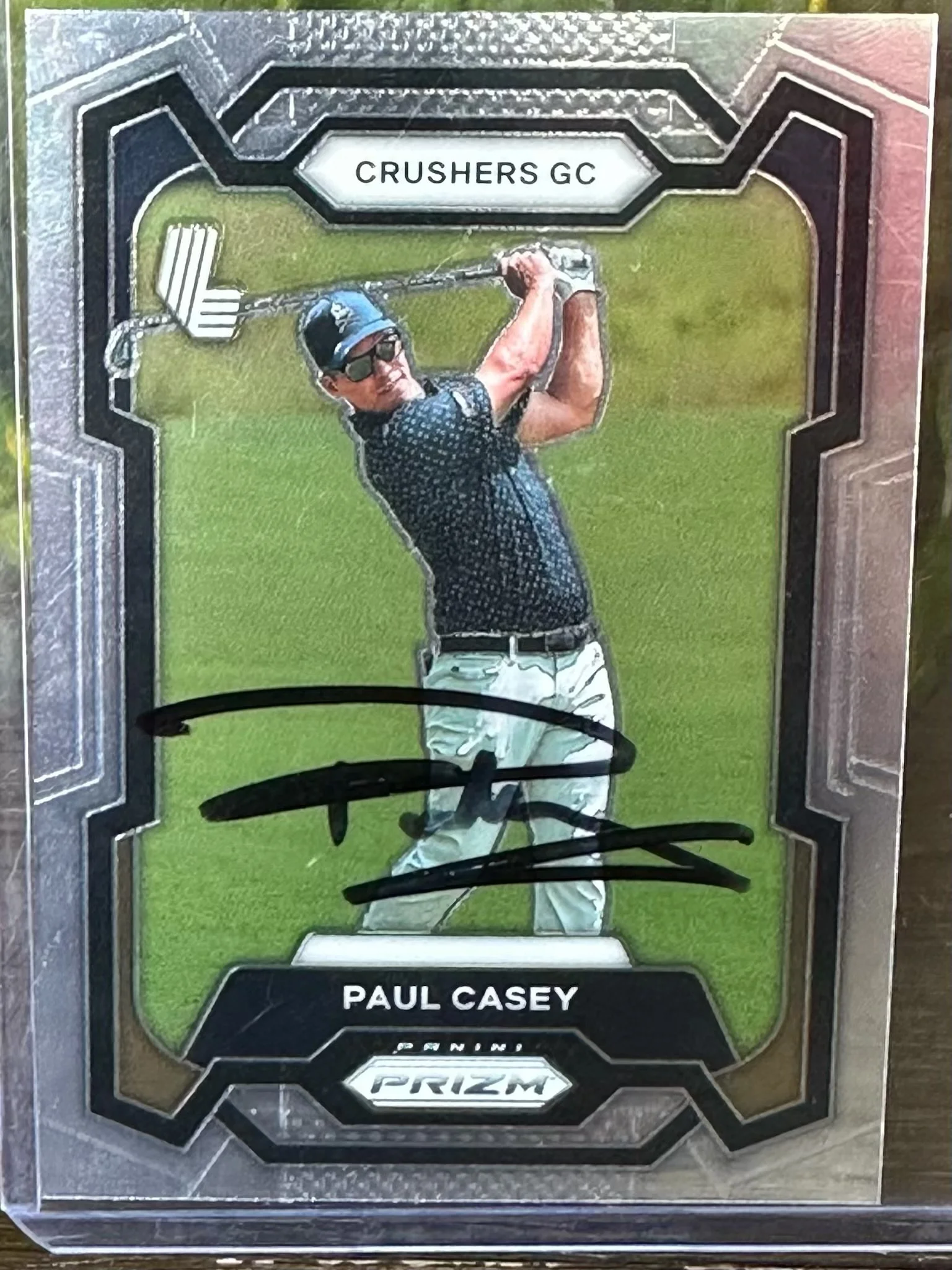 Autographed trading card of golfer Paul Casey from the Panini Prizm Crushes GC series, featuring him swinging a golf club on a green field.