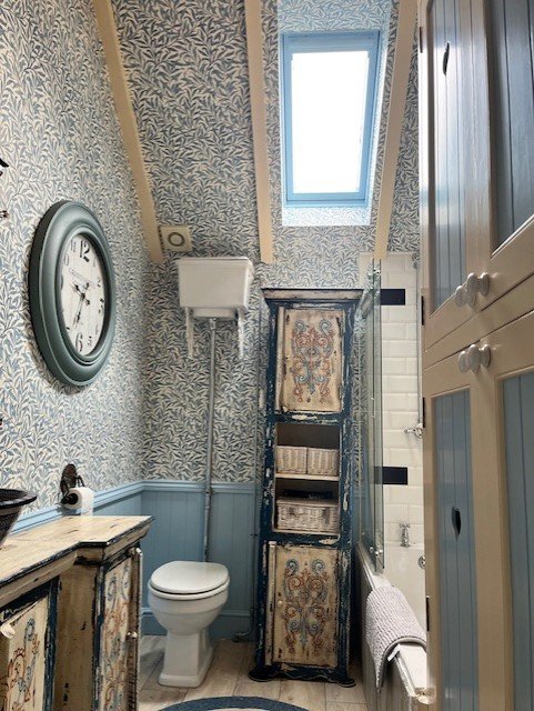 Bathroom wallpaper installation in Tollesbury with wallpapered ceiling and walls by Bergman Decorations.