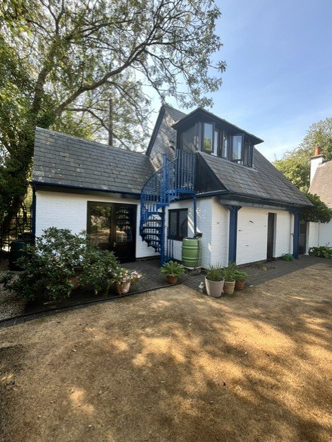 Unique exterior view of Bridge House showing spiral staircase, with all metalwork professionally coated in Hammerite Smooth Blue and surrounding timber finished in Sadolin Obsidian. 