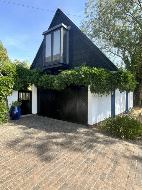 Exterior decorating project in Bicknacre featuring Sadolin Superdec in Obsidian on the timber cladding, windows and garage doors, with freshly painted white brickwork creating a sharp modern contrast.
