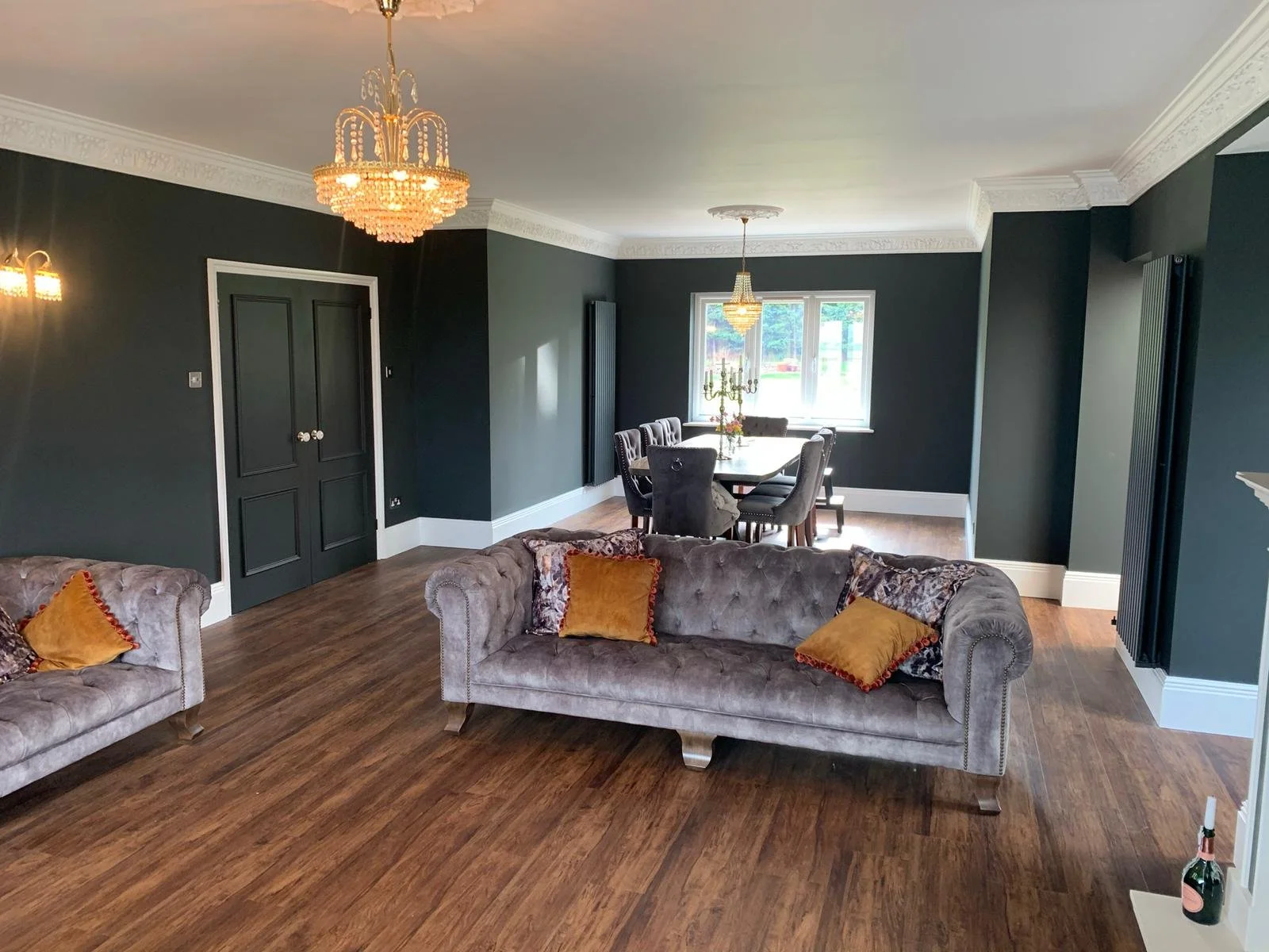 Open-plan lounge and dining area decorating in Manningtree with black painted walls, sprayed decorative cornice and a consistent high-quality finish across the space.