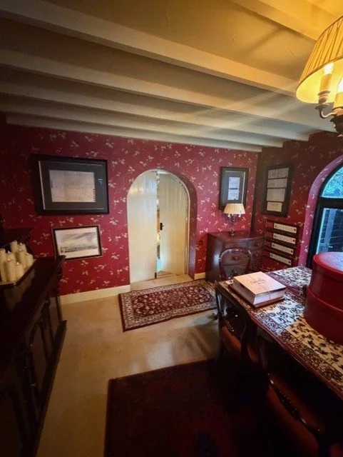 A detailed view of this dining room redecoration in Tollesbury, featuring newly wallpapered walls, freshly painted ceiling beams and carefully finished details around the original arched doorway.