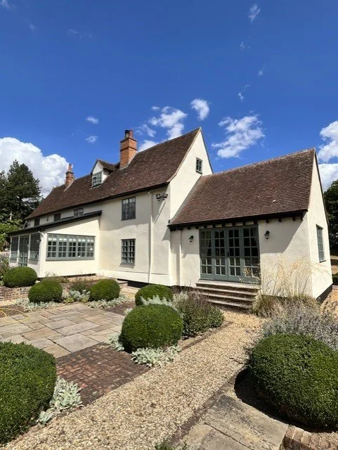 Rear garden elevation showing freshly painted masonry in Bedec Super-Flex Gardenia, traditional green painted windows and black exterior joinery, professionally completed by Bergman Decorations.