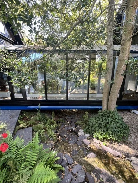 Close-up view of the distinctive bridge structure linking two parts of the property, featuring Hammerite Smooth Blue metalwork and freshly decorated exterior timber and window frames. 