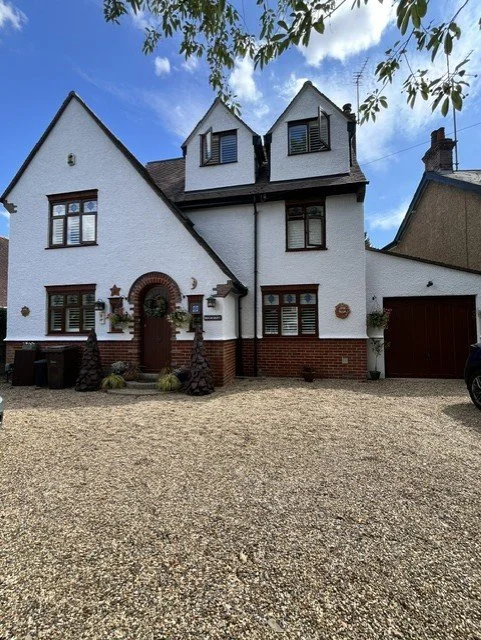 Exterior house painting project in Colchester, Essex. Fresh white rendered walls with contrasting black facias, and soffits, complimented by burnt orange windows and doors. Professionally prepared and painted by Bergman Decorations.