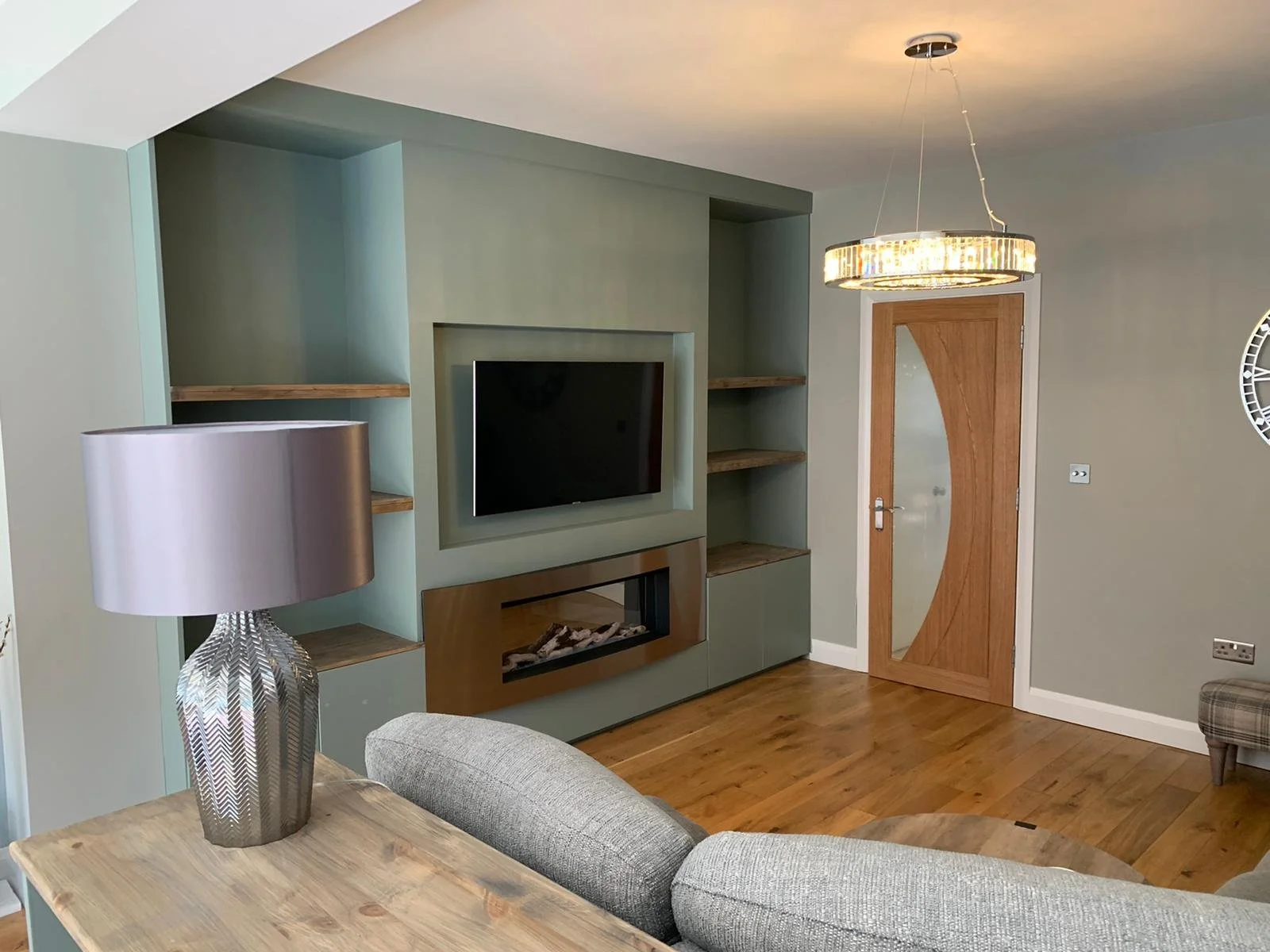 Built-in media wall and shelving painted in grey tones as part of lounge redecoration in Maldon