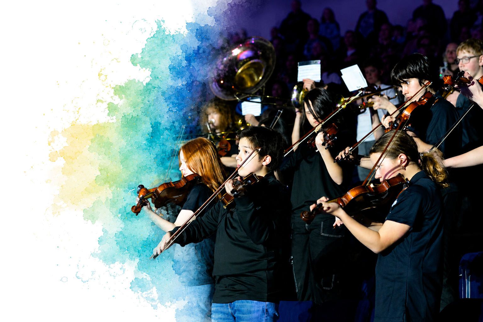 An orchestra of children playing violins and other instruments during a performance.