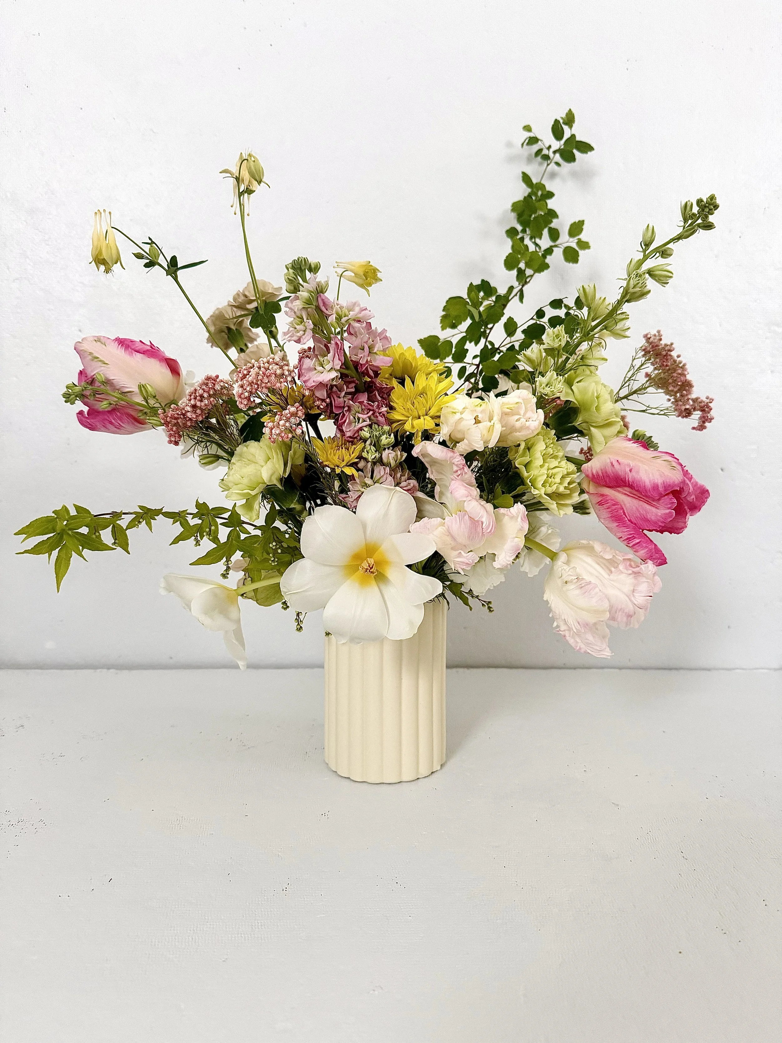 Medium+floral+arrangment+in+cream+ribbed+vase+.jpg