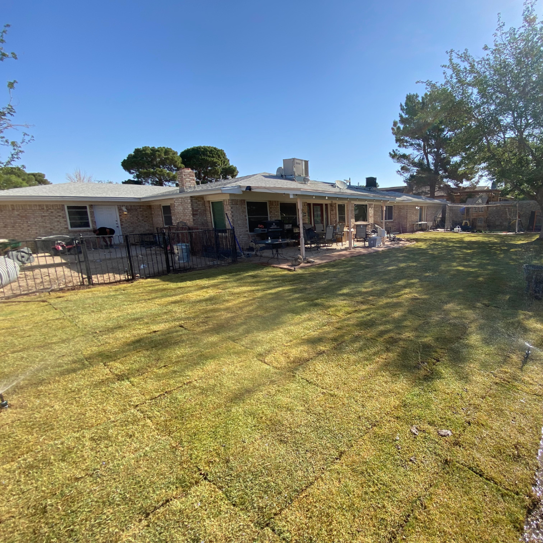 Backyard with a brick house, patio, outdoor furniture, a grill, and a fenced area.
