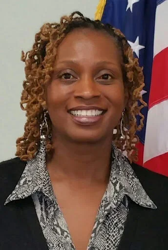 Tracy Gant Democrat for Maryland house of Delegates in District 22, with curly hair in front of an American flag.