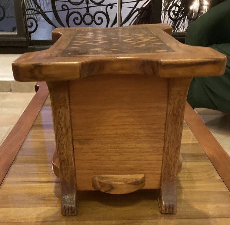 Wooden side table with a carved drawer handle