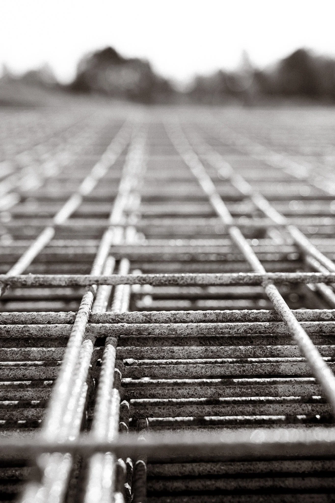 Close-up view of metal rebar on a construction site with a blurred background.