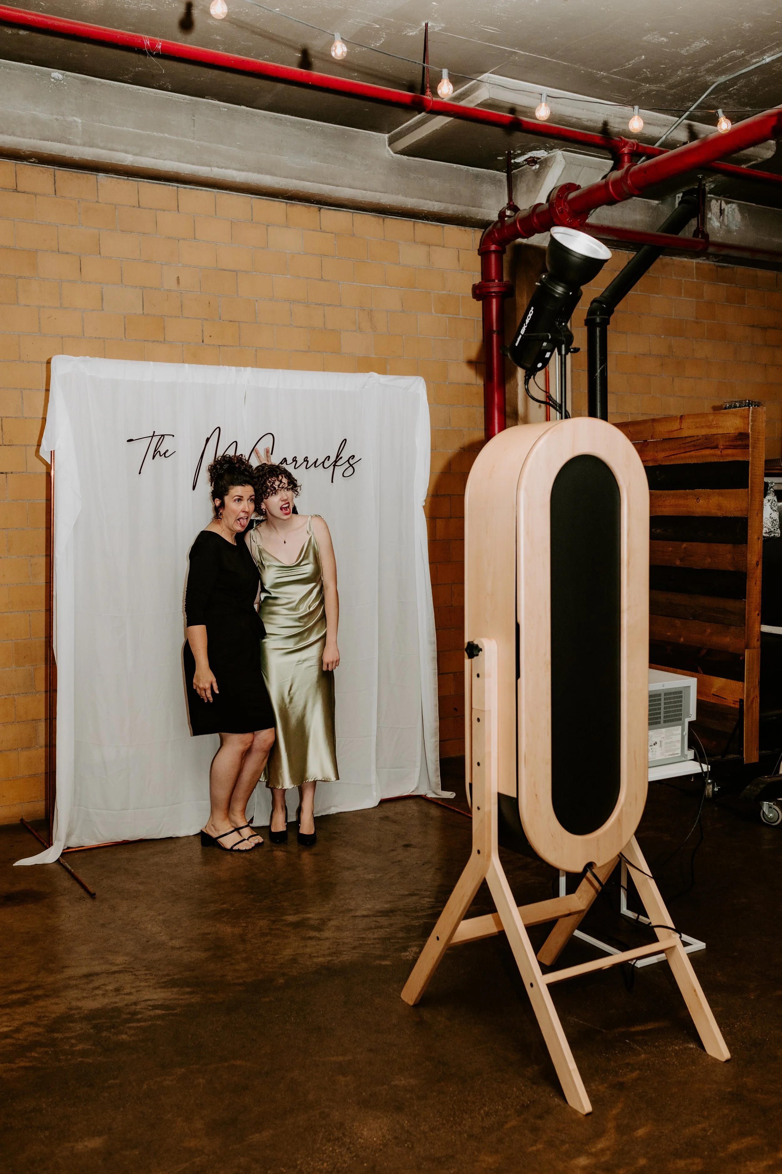 Guests posing inside modern open-air photo booth at wedding reception