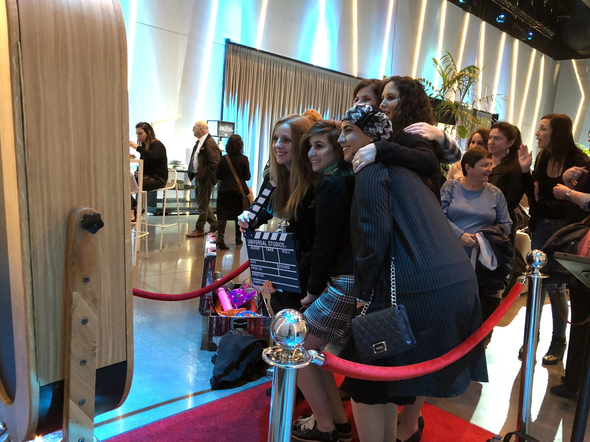 Corporate team taking branded photo booth pictures at company party