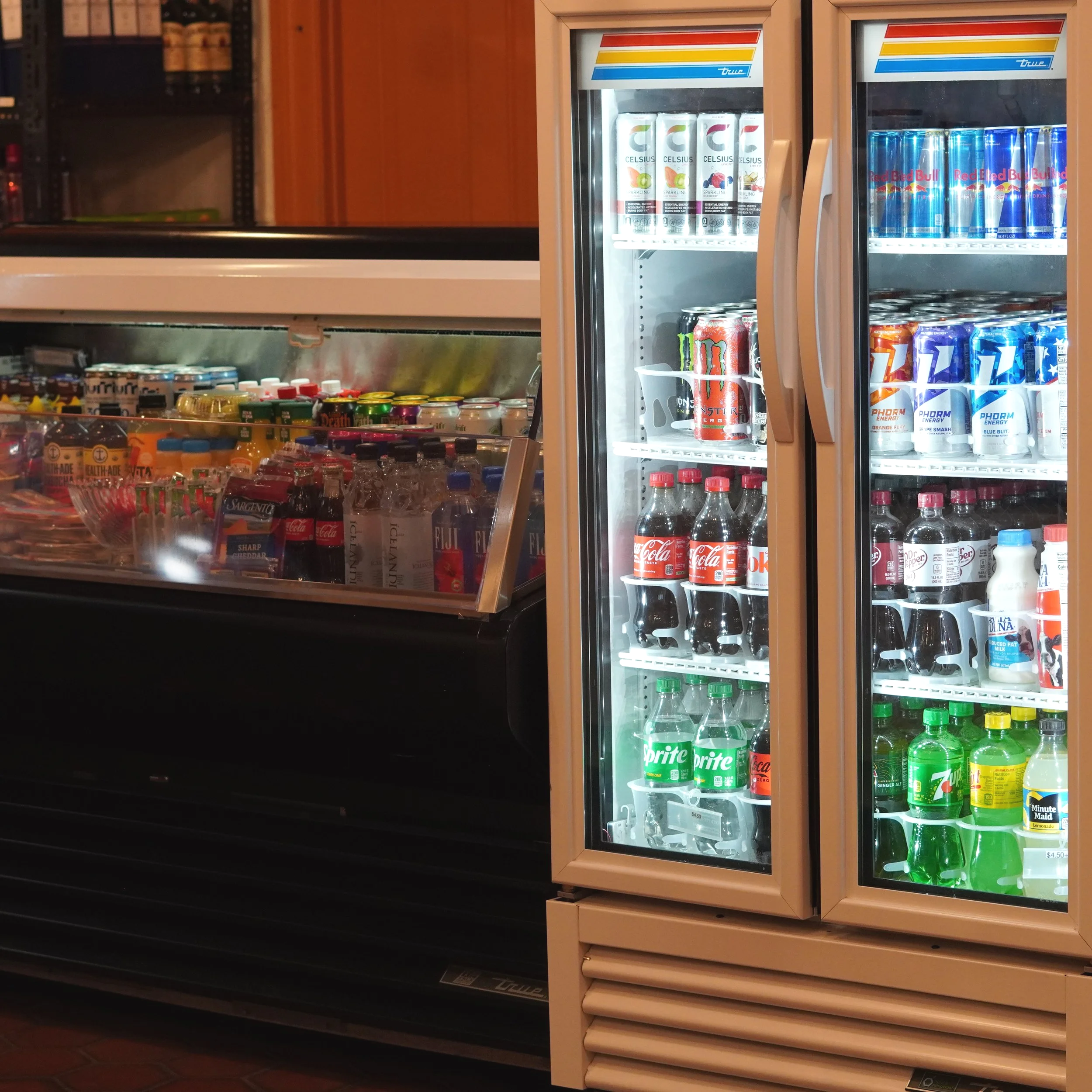 Refrigerators filled with various beverages in a convenience store, including energy drinks, sodas, and bottled water. Grab and go snacks and drinks at The French Kitchen , Westin Bonaventure