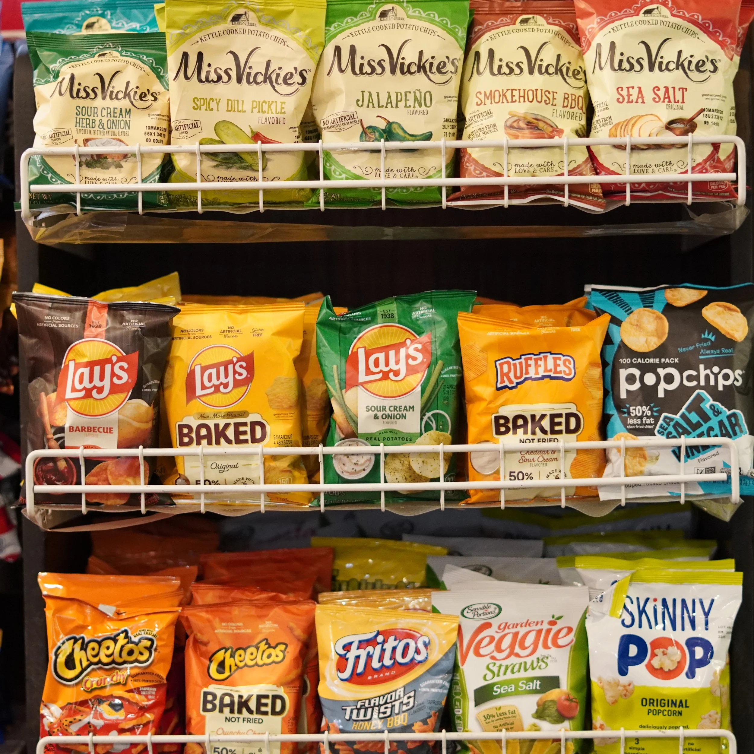 Snack snacks on store shelves including Miss Vickie's kettle chips, Lay's baked and sour cream & onion chips, Ruffles baked chips, Pop Chips sea salt chips, Cheetos crunchy cheese snacks, Fritos honey BBQ chips, Garden Veggie sea salt straws, and Ski