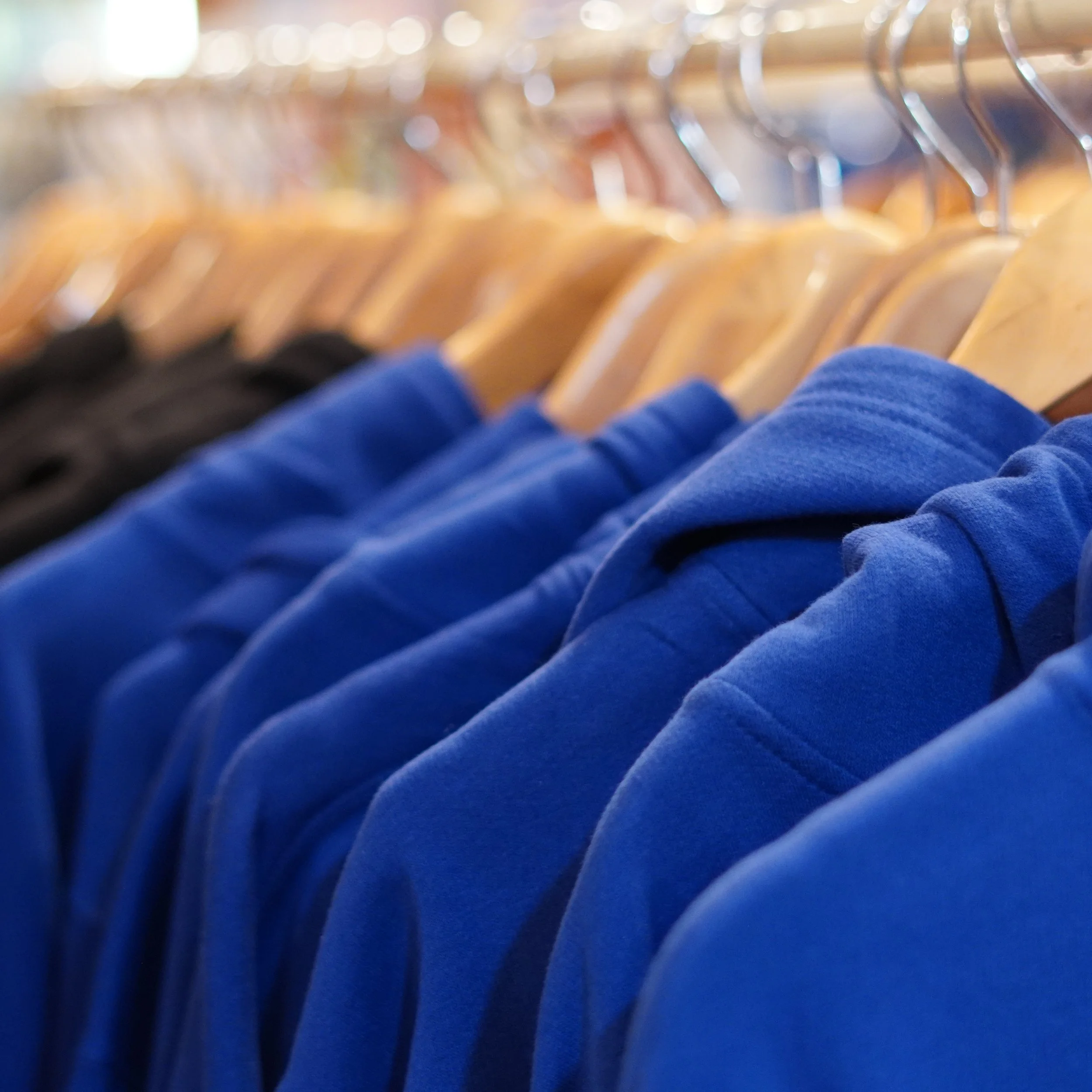 Blue and black T-shirts hanging on a clothing rack in The French Kitchen, all-in-one store inside the Westin Bonaventure