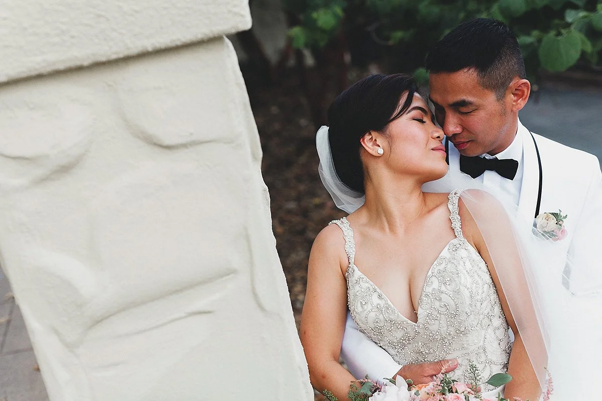 A bride and groom share a tender moment, their foreheads touching, during their wedding celebration.