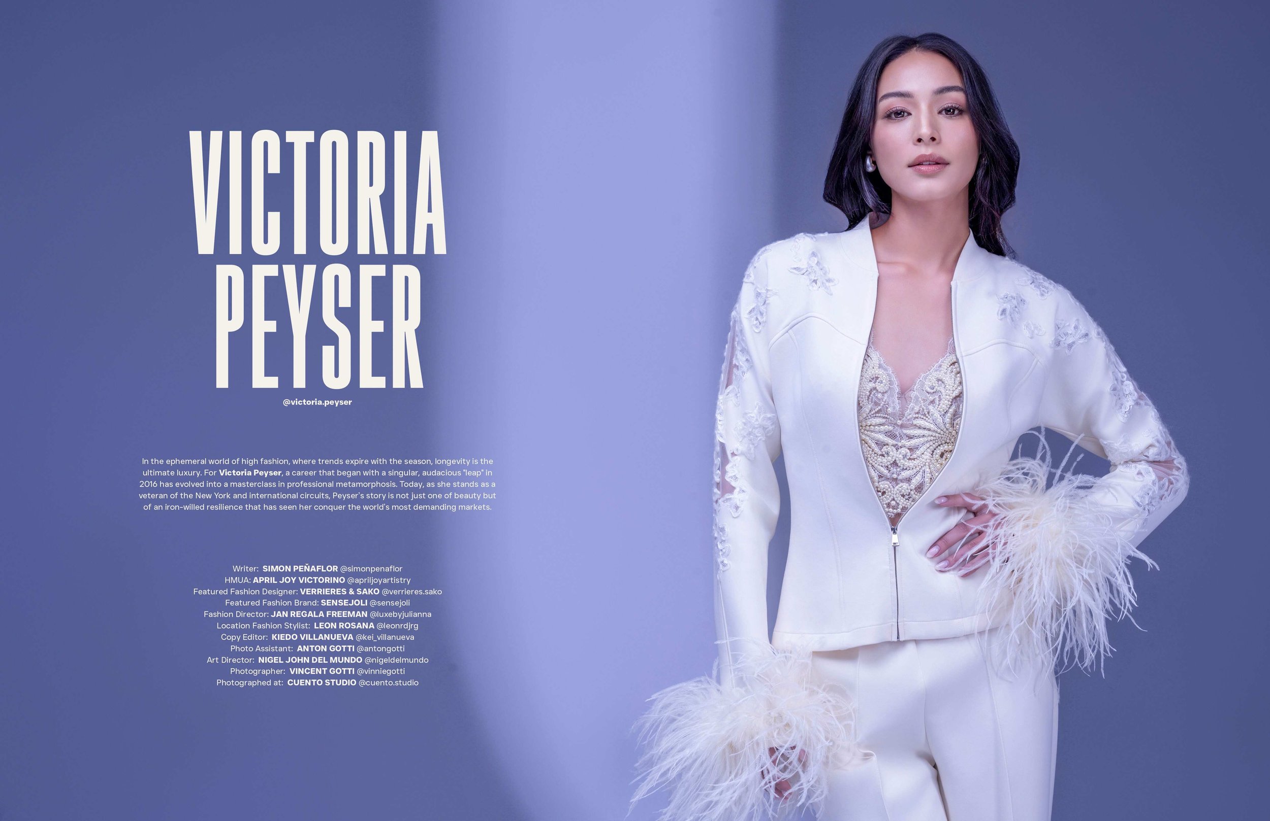 A woman with dark hair and fair skin wearing a white outfit with feathered details on the sleeves and hem, standing against a blue background with text on the left side reading "Victoria Peyser" and additional text below.