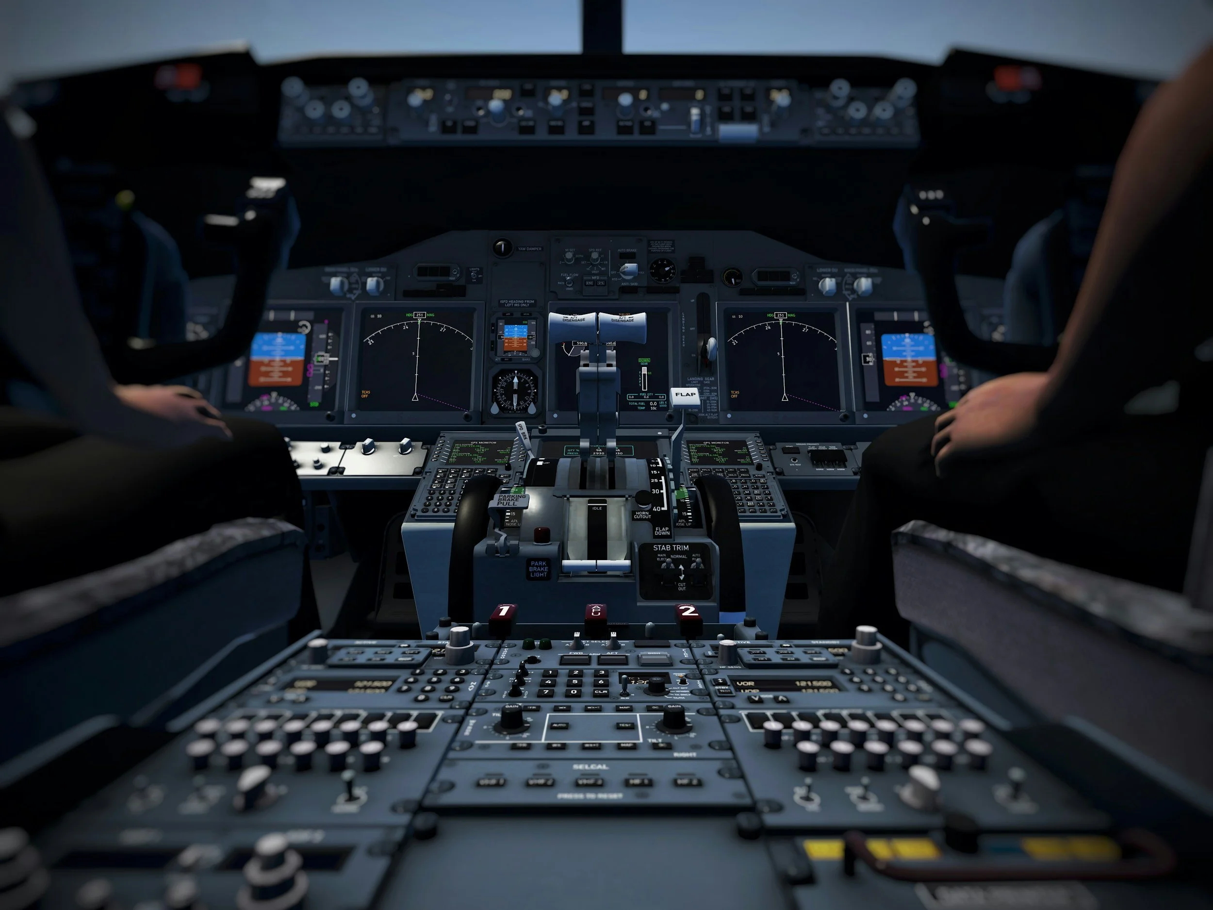 View of an airplane cockpit with control panels, screens, and pilot hands.