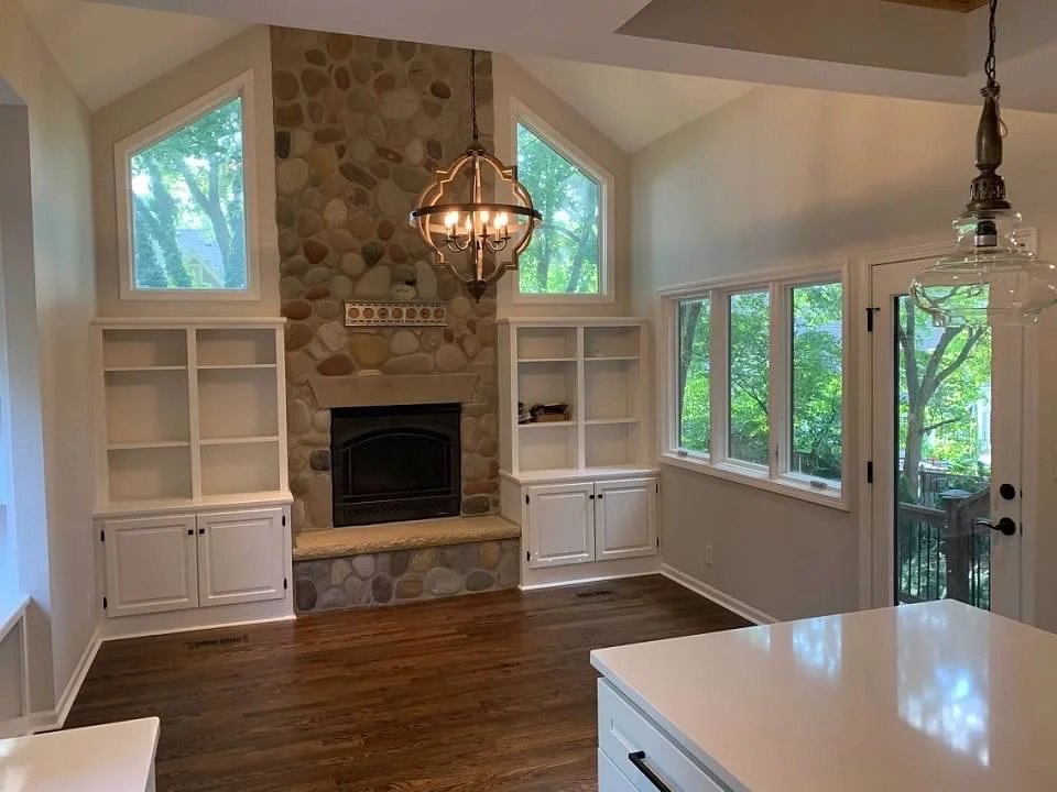 Fireplace hearth room with built in cabinetry, chandelier, valted ceiling