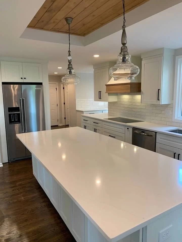 Kitchen with custom range hood, stainless steel appliances and quartz countertops