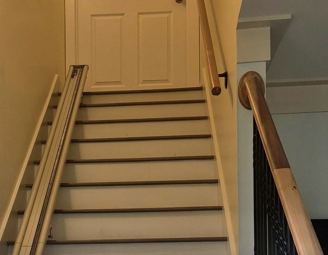 New railings, installed and stained, against black iron balusters