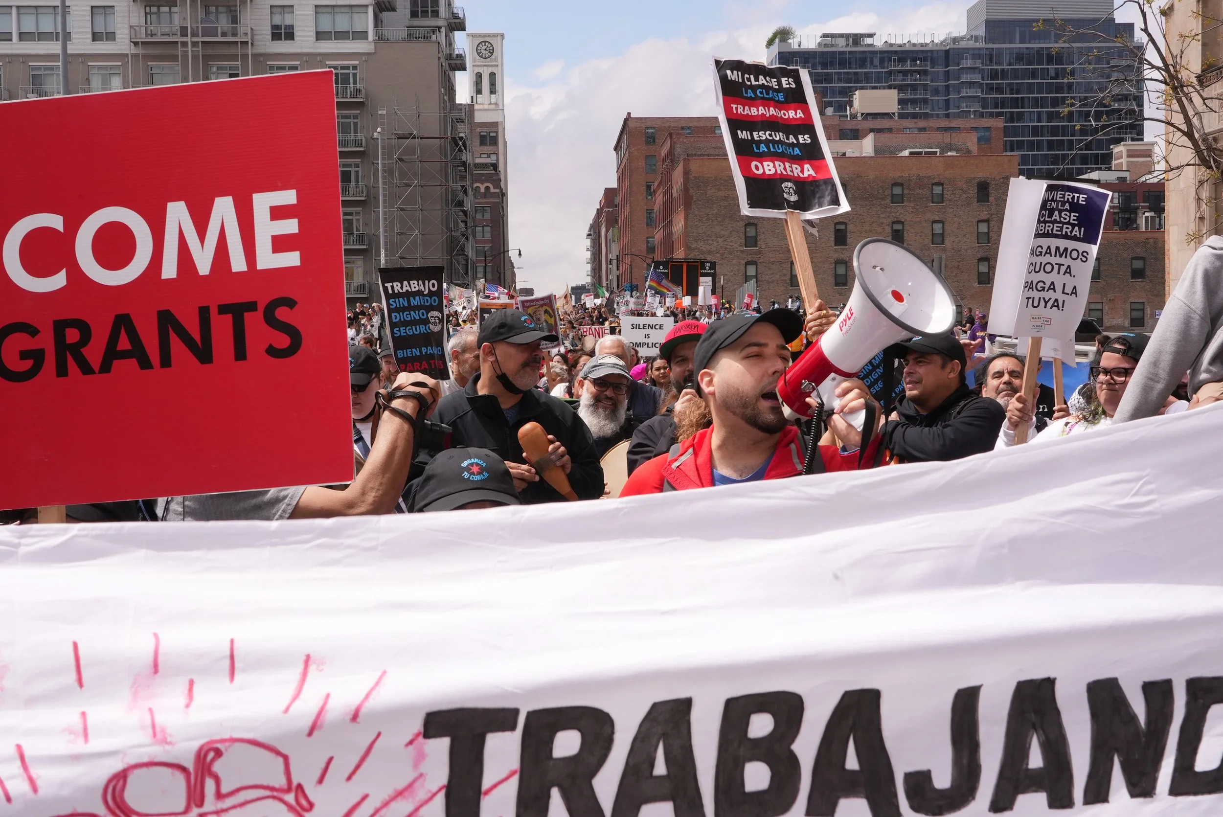 Miguel Alvelo-Rivera holds a megaphone and leads teh crowd in chants during a May Day 2025 march