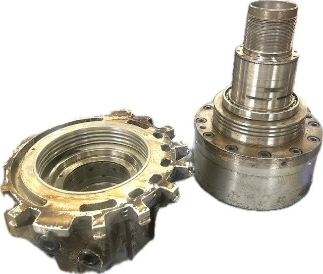 Metal mechanical parts, one with gear-like teeth and the other with a shaft, placed on a white background.