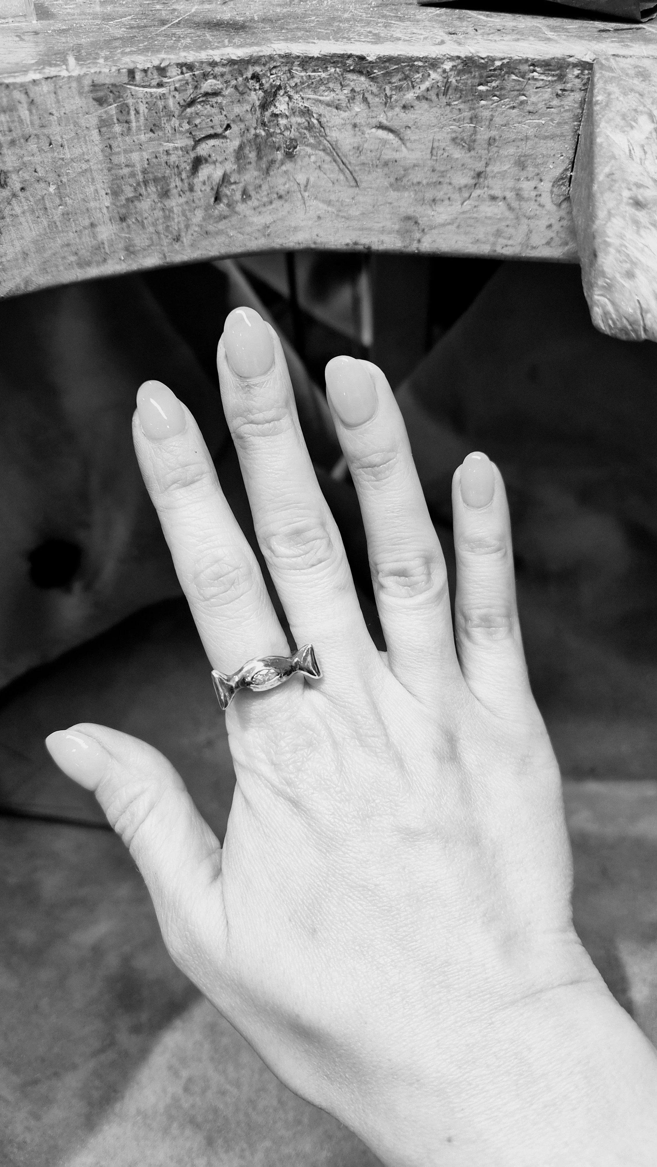Candy Wrapper Diamond Ring in sterling silver resting on wood — hand-carved wearable sculpture, Atelier Moroti London
