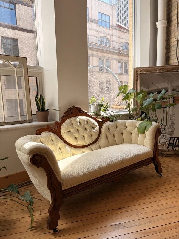 Antique cream tufted chaise lounge in the main event hall at The Harlow Exchange heritage venue in Winnipeg's Exchange District