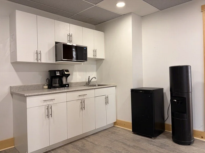 Kitchenette in the prep room at The Harlow Exchange event venue in Winnipeg featuring microwave, coffee maker, mini fridge, water cooler and sink