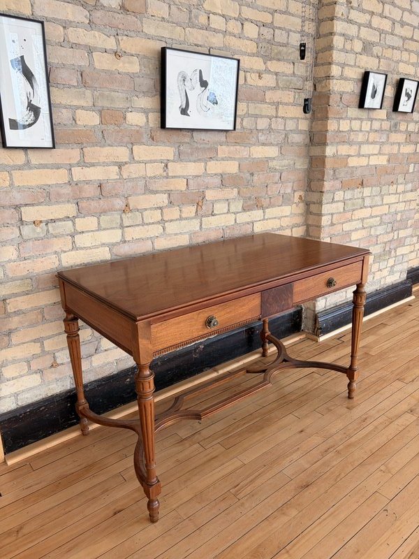 Antique wooden desk against exposed brick wall at The Harlow Exchange event venue in Winnipeg's Exchange District