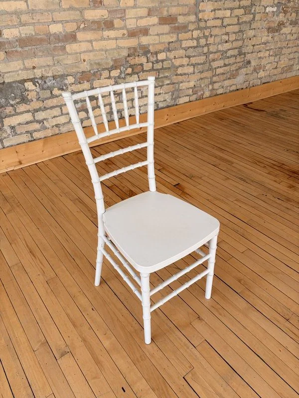 White Chiavari chair on hardwood floors against exposed brick wall at The Harlow Exchange wedding venue in Winnipeg's Exchange District