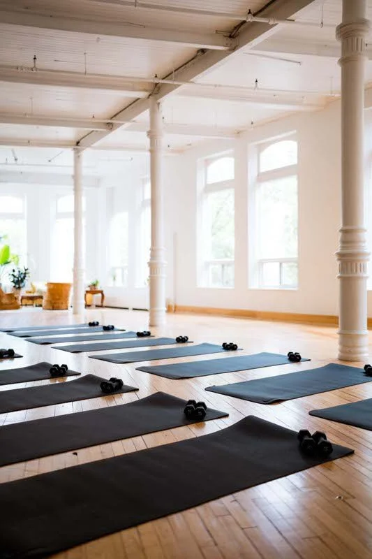 Yoga mats and dumbbells set up for a fitness event in the main hall at The Harlow Exchange heritage venue in Winnipeg's Exchange District