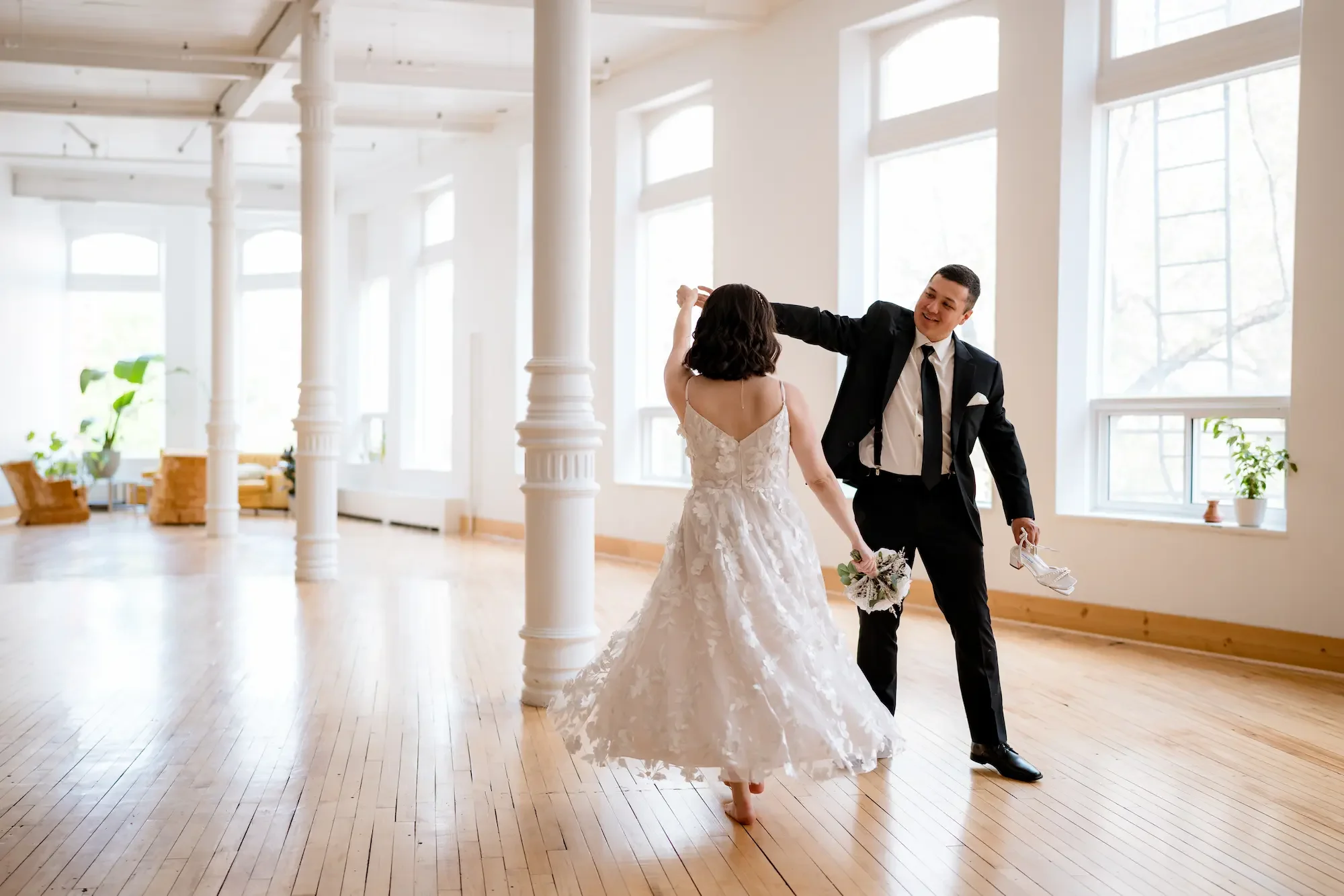 Couple dancing at The Harlow Exchange wedding ceremony venue surrounded by ornate columns and natural light in Winnipeg