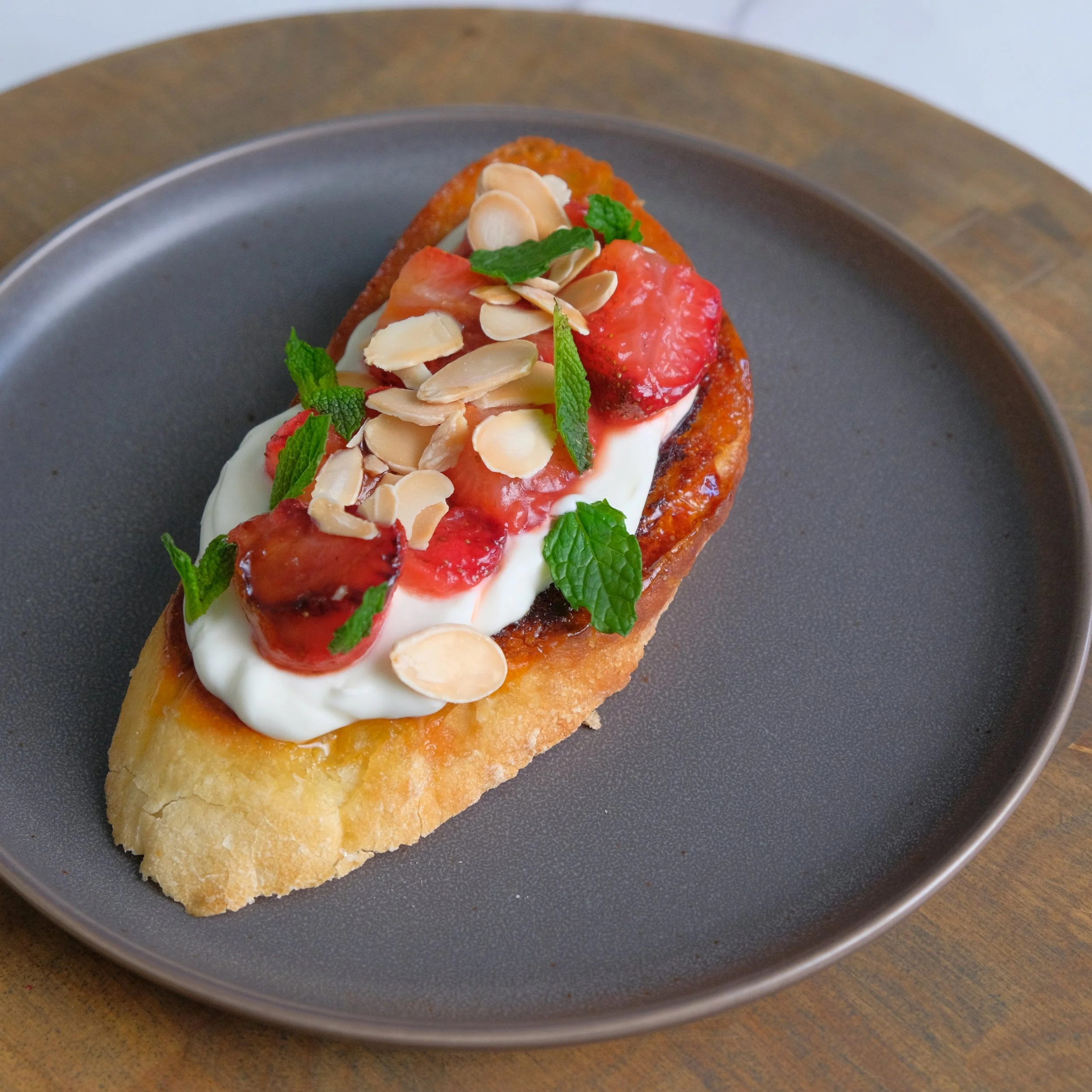 Chared strawberry toast with with whipped Crème fraîche, on sourdough bread
