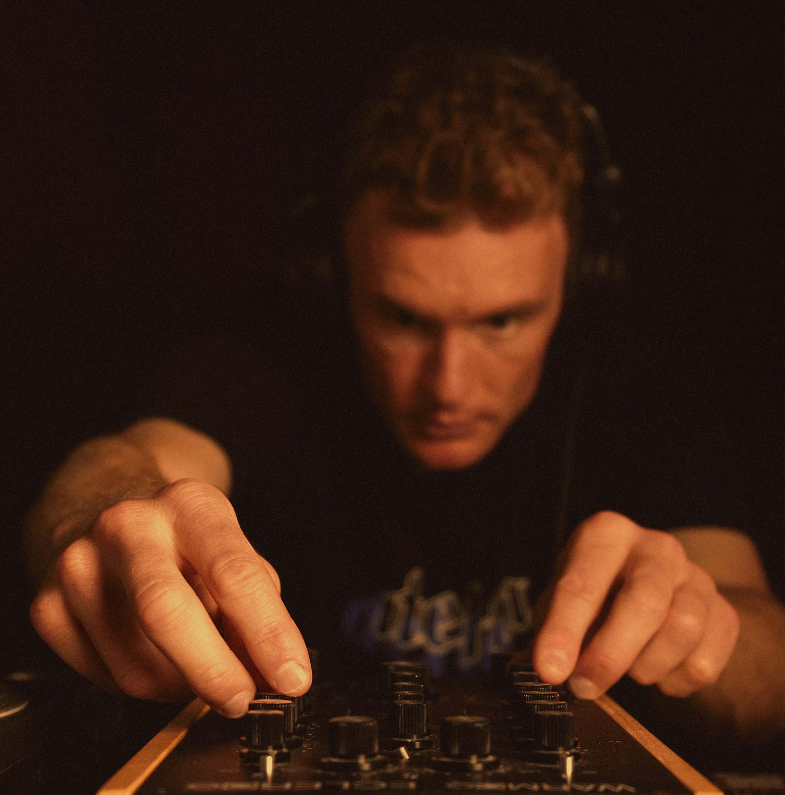 vintage color portrait close up of DJ hands turning knobs on mixer