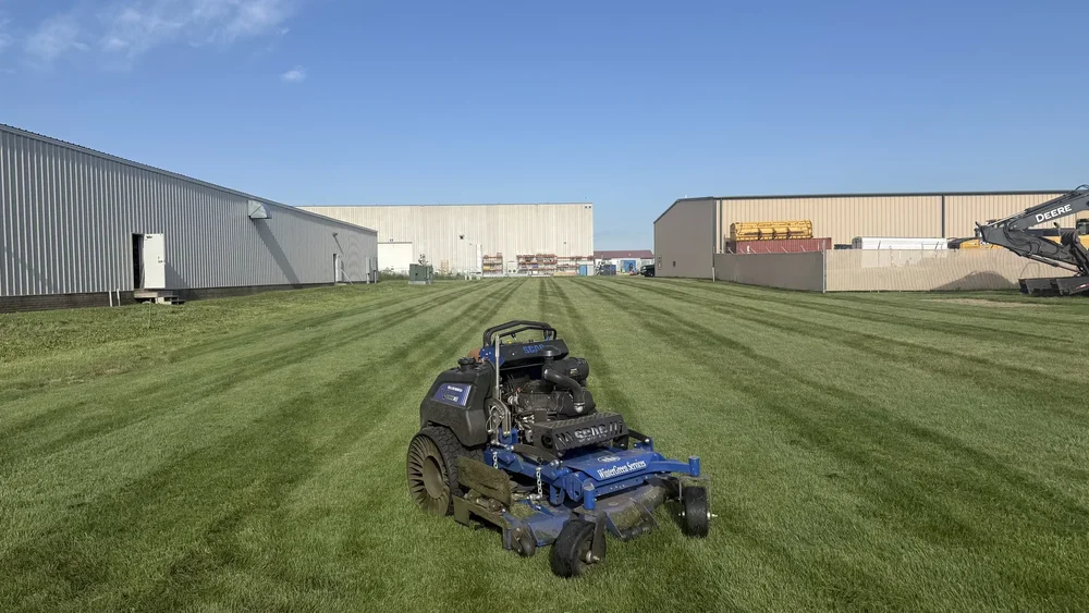 Striped commercial lawn maintained between two warehouse buildings