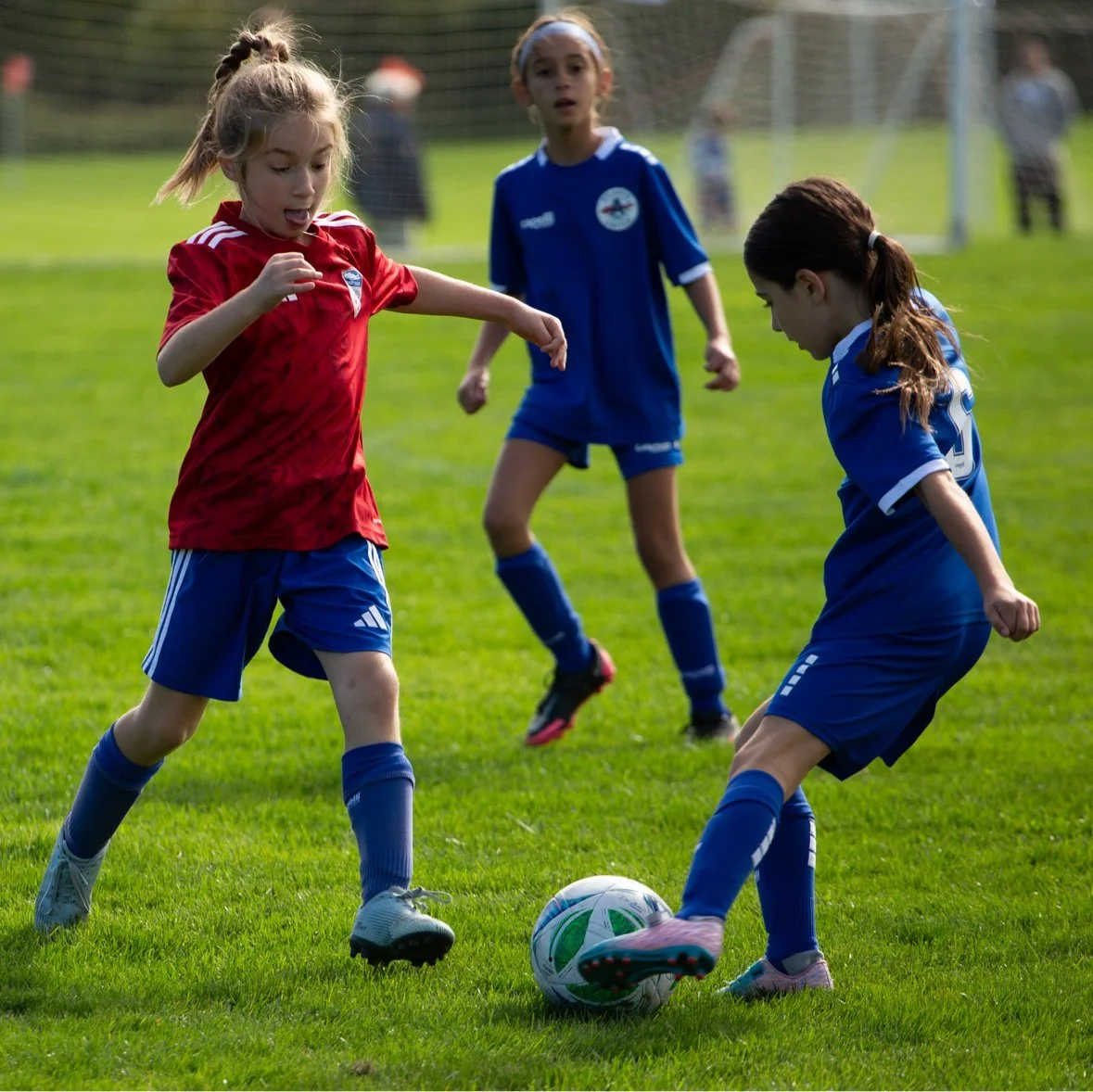 Girl challenging two defenders for the ball — sports photography in Long Island