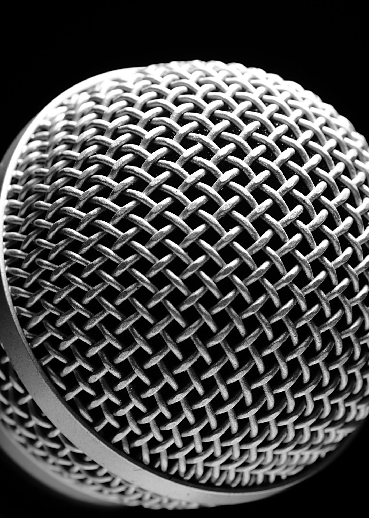 Close-up of a microphone head showing a metallic mesh grille with a crisscross pattern.